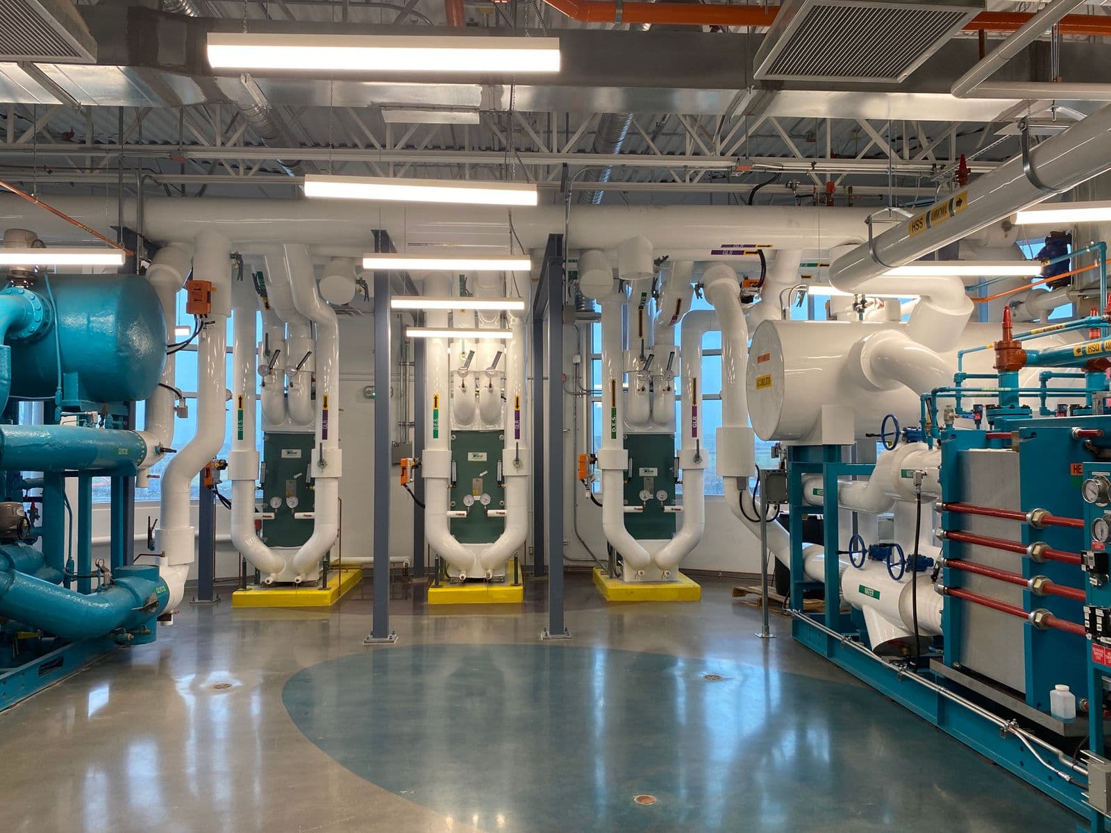 Kälteanlage mit Pumpen, Rohrleitungen und Wärmetauschern in einem Technikraum