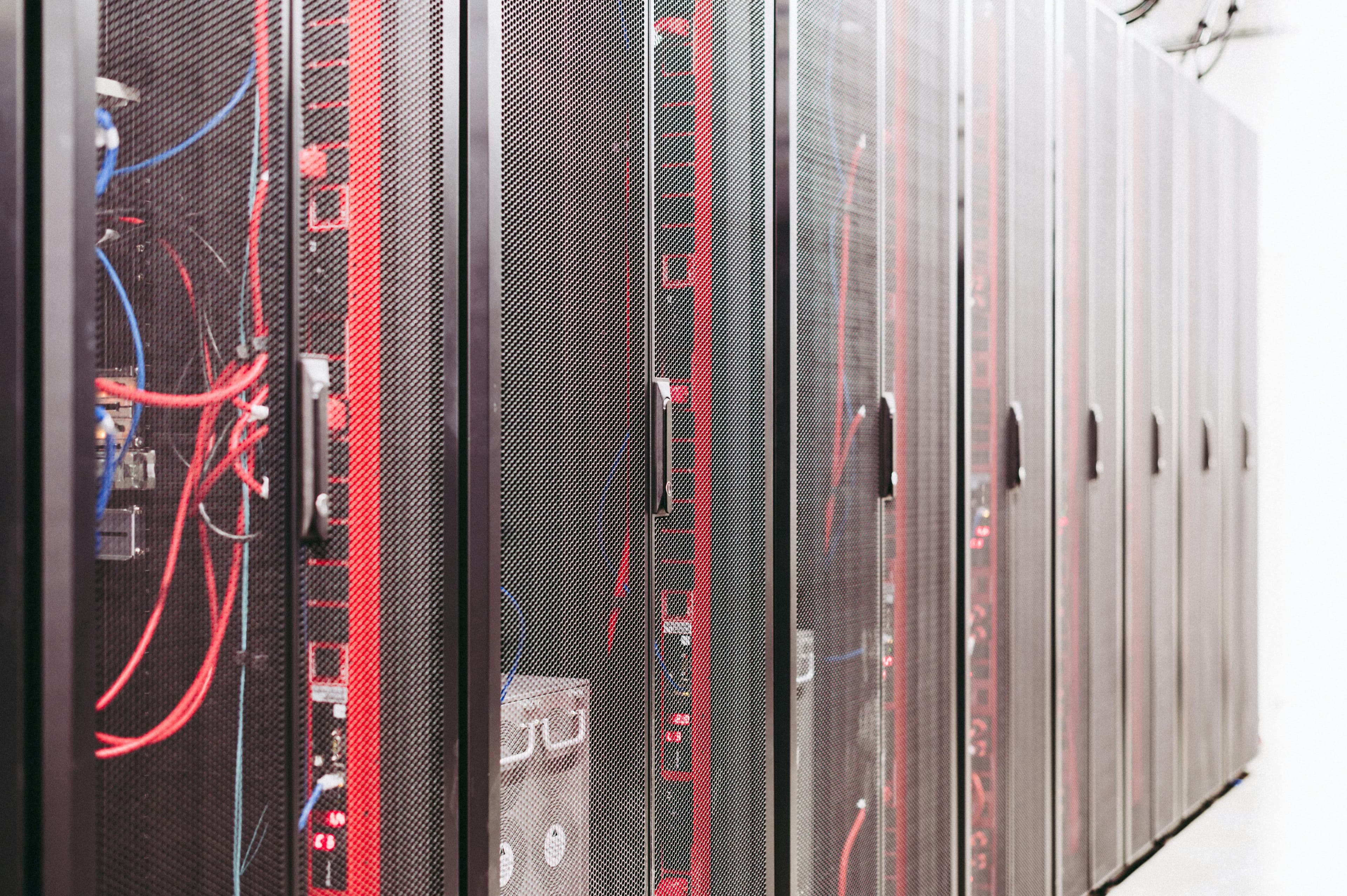 Server cabinets with red and blue cabling in a data center aisle