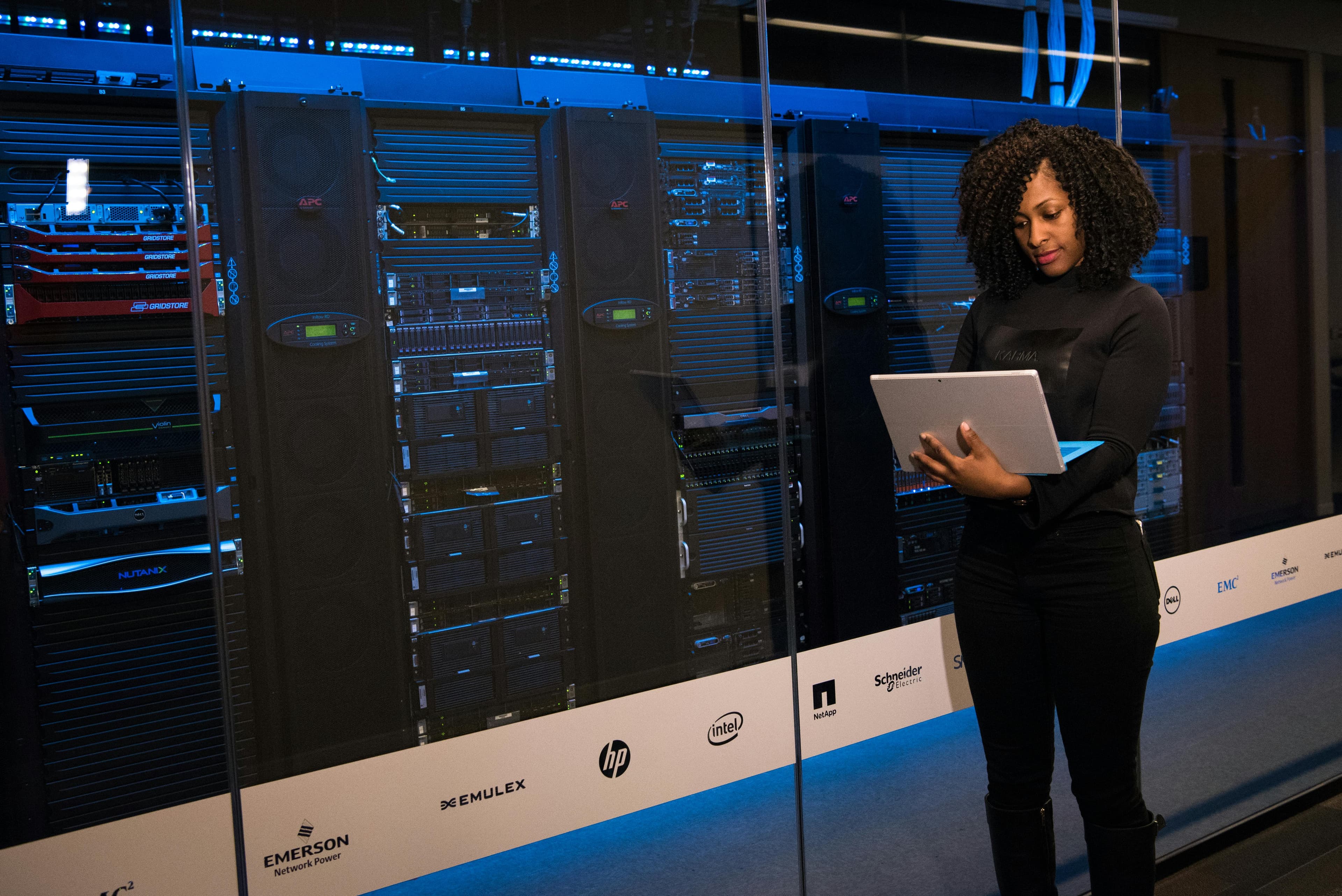 Technician using a tablet in front of server and power equipment