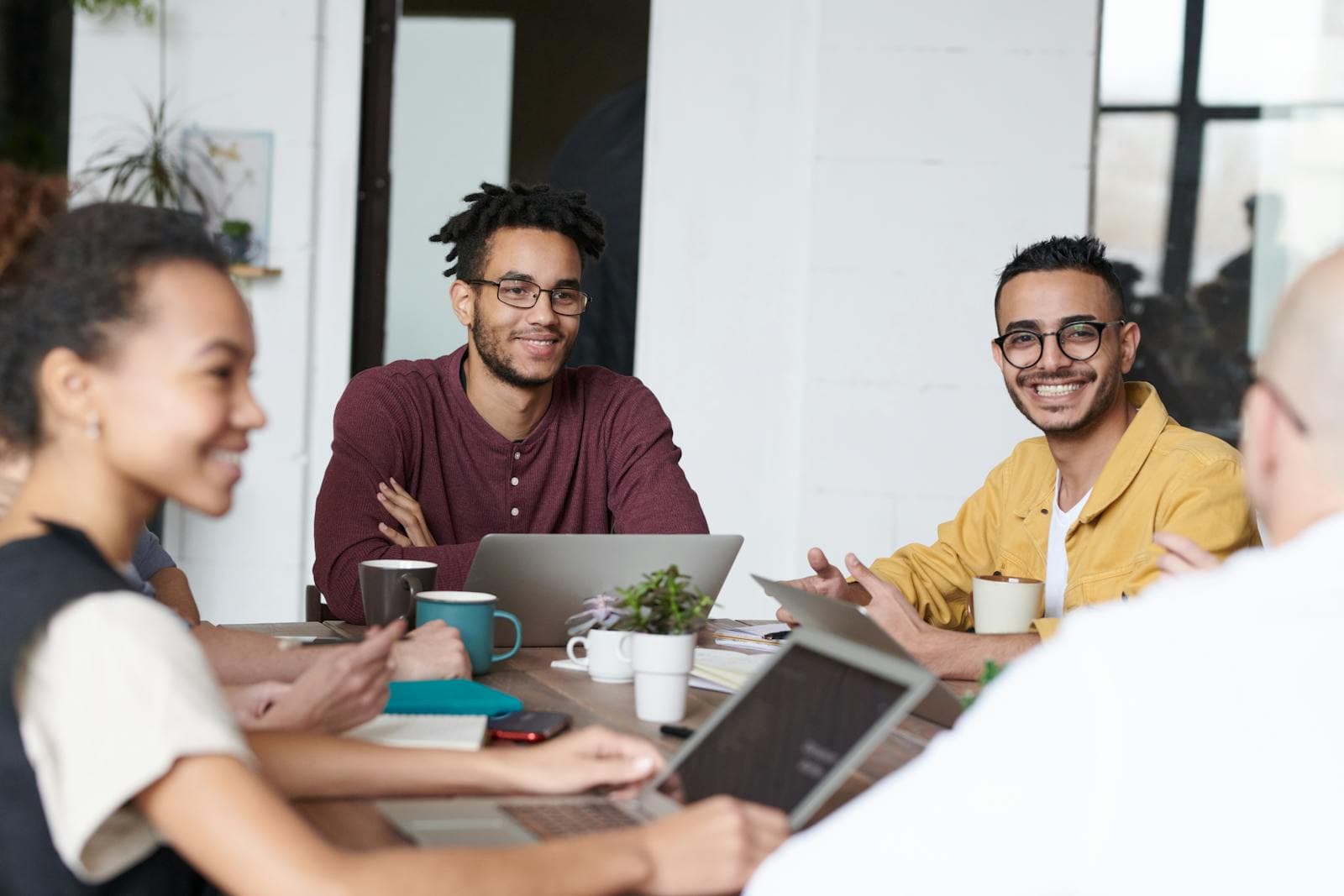 Group of professionals collaborating with laptops in a shared workspace