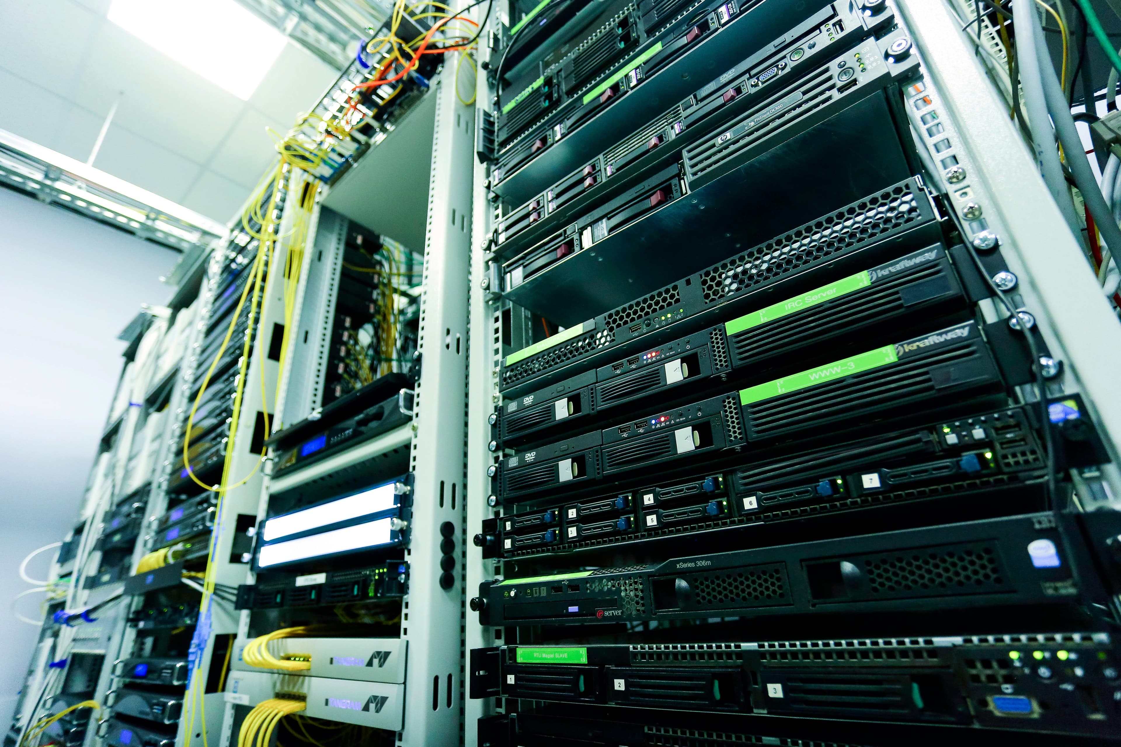 Server racks and network cabling inside a data center aisle