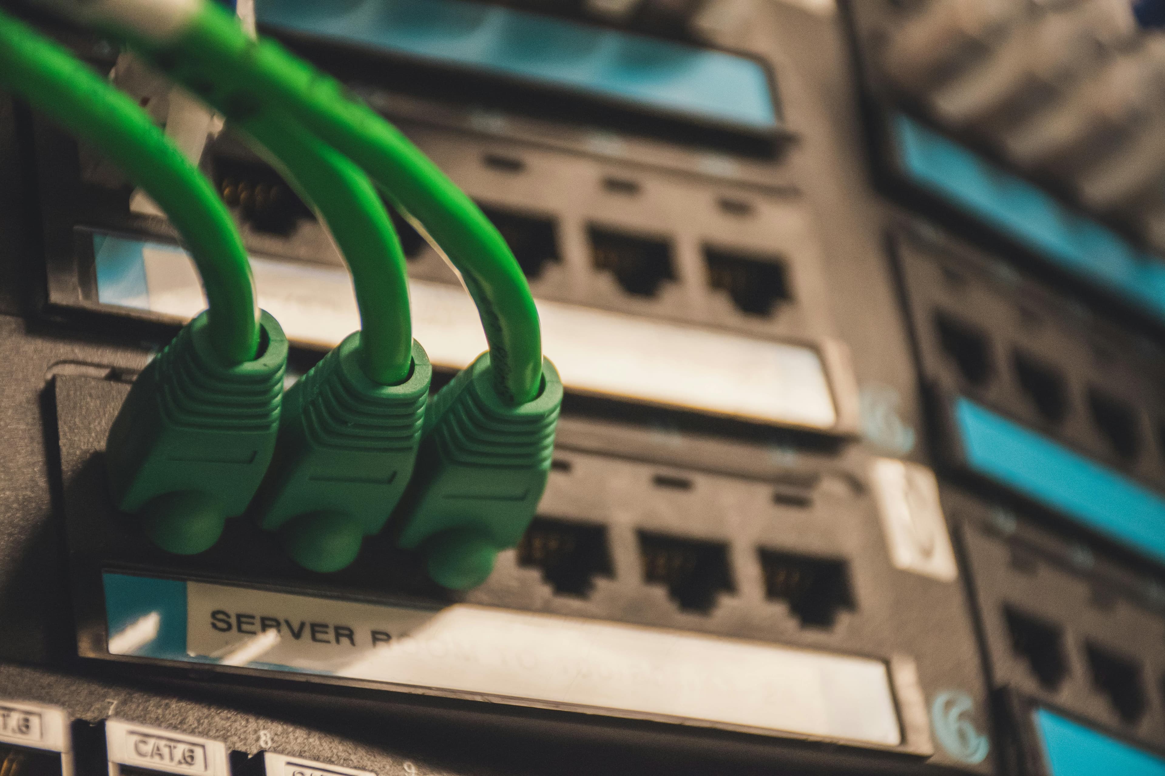 Green network cables connected to server ports in a rack