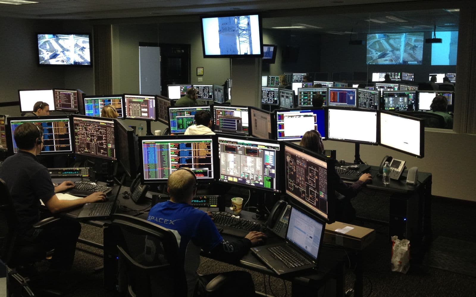 Operations team working across several monitors in a technical control room