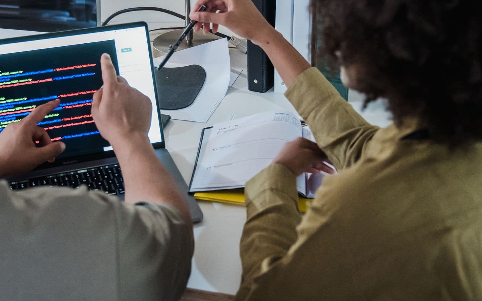 IT-Team bei der gemeinsamen Prüfung von Code auf Laptops