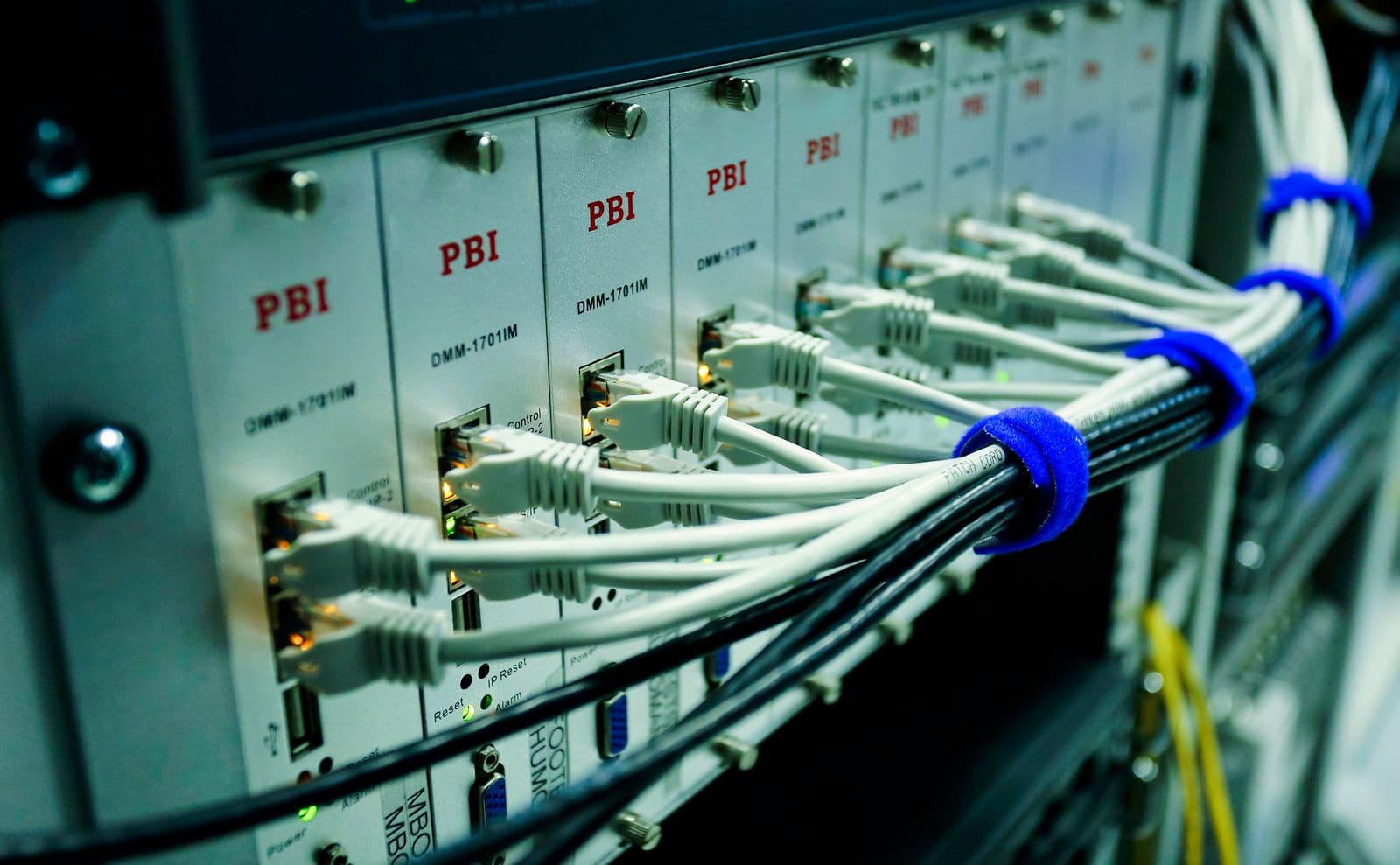 Gebündelte graue Ethernetkabel an mehreren Gerätemodulen in einem Rack