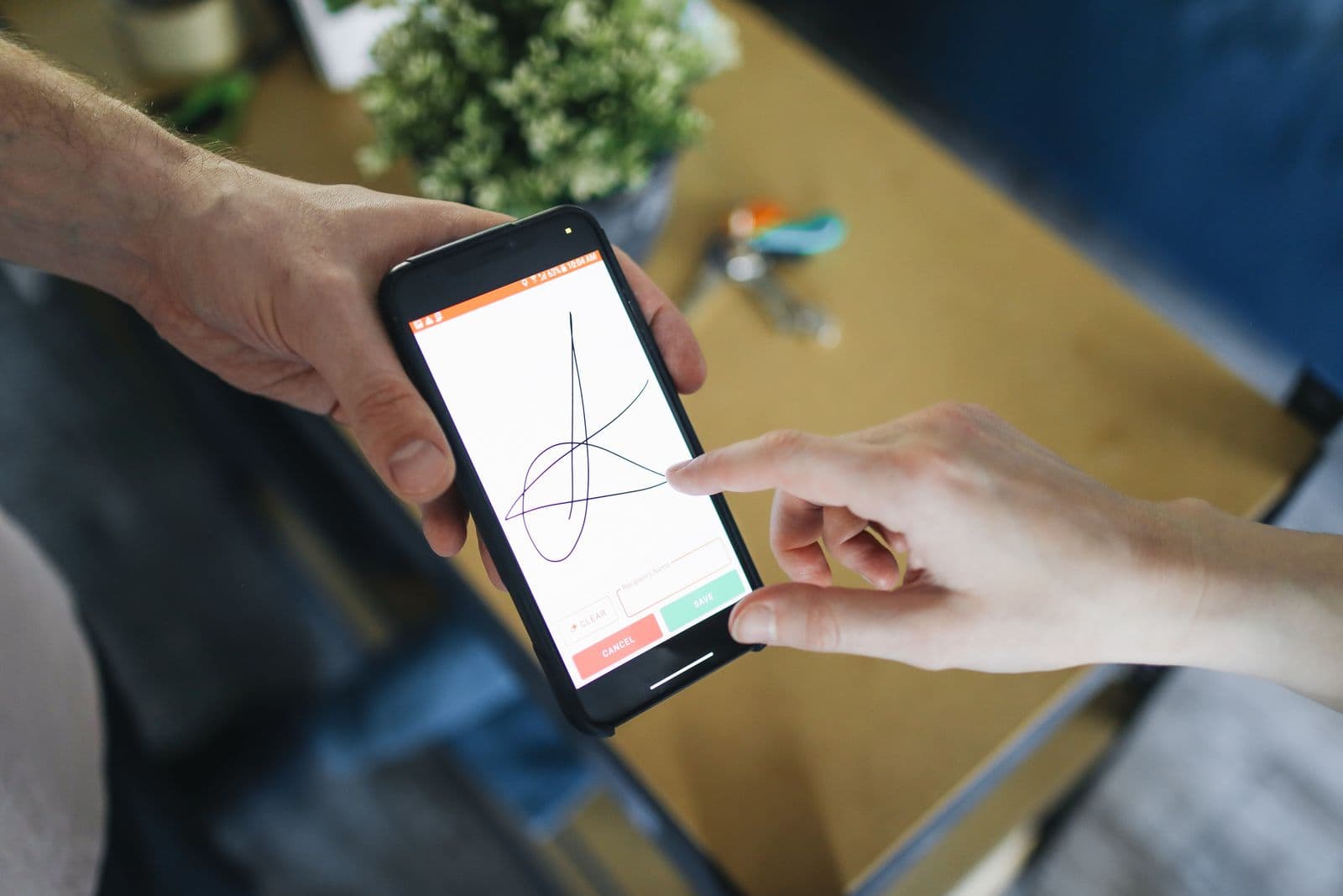 Zwei Personen bestätigen einen Vorgang über ein Mobilgerät