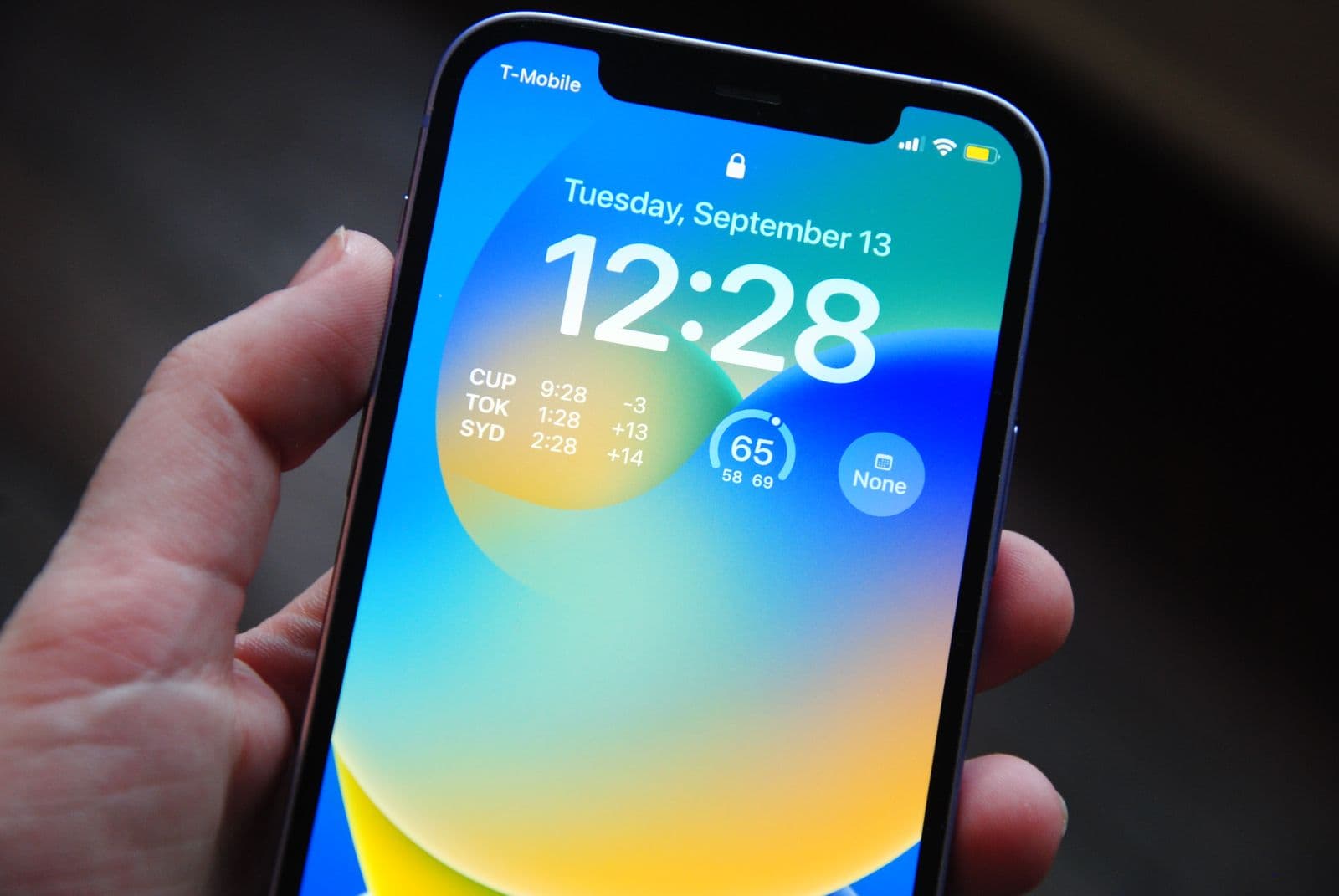 Smartphone mit sichtbarem Sperrbildschirm in einer Hand