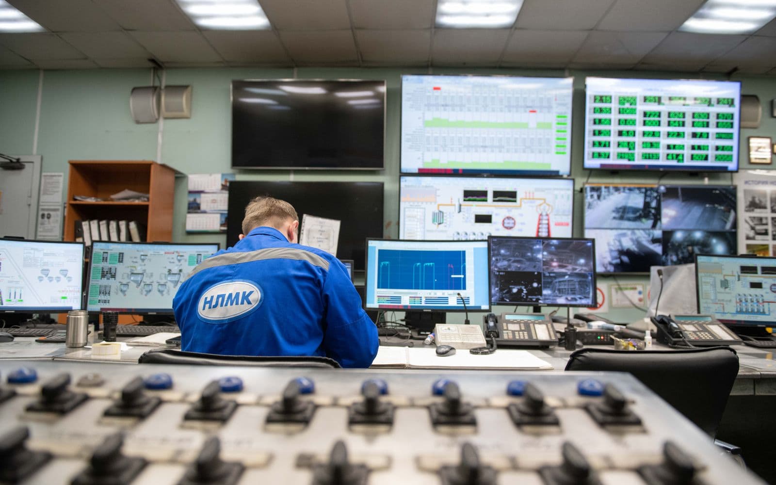 Engineer monitoring multiple screens in a control room