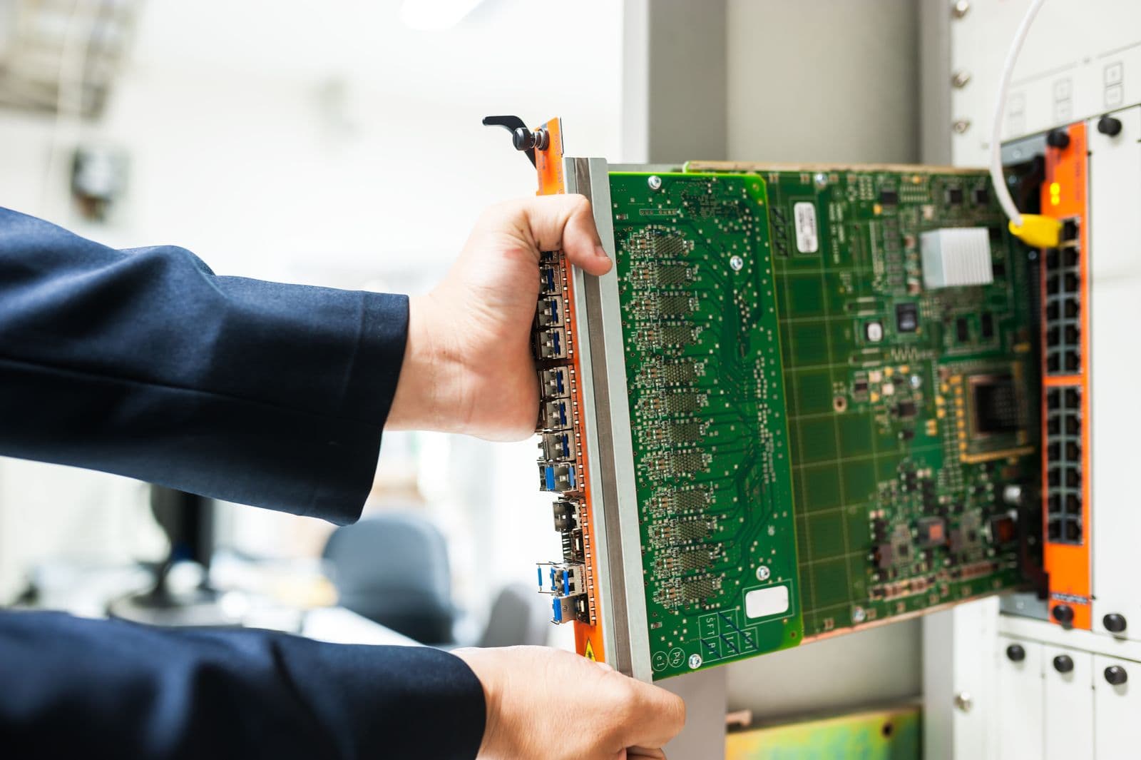 Techniker beim Ausbau eines Netzwerkmoduls aus einem Infrastruktursystem