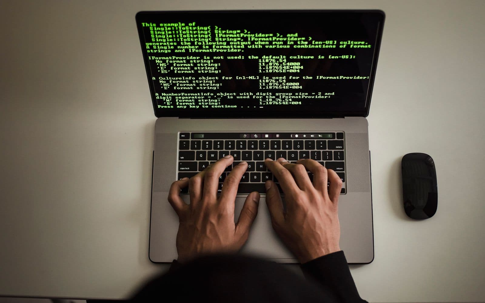 Person bei einer Sicherheitsprüfung an einem Laptop mit Quellcode