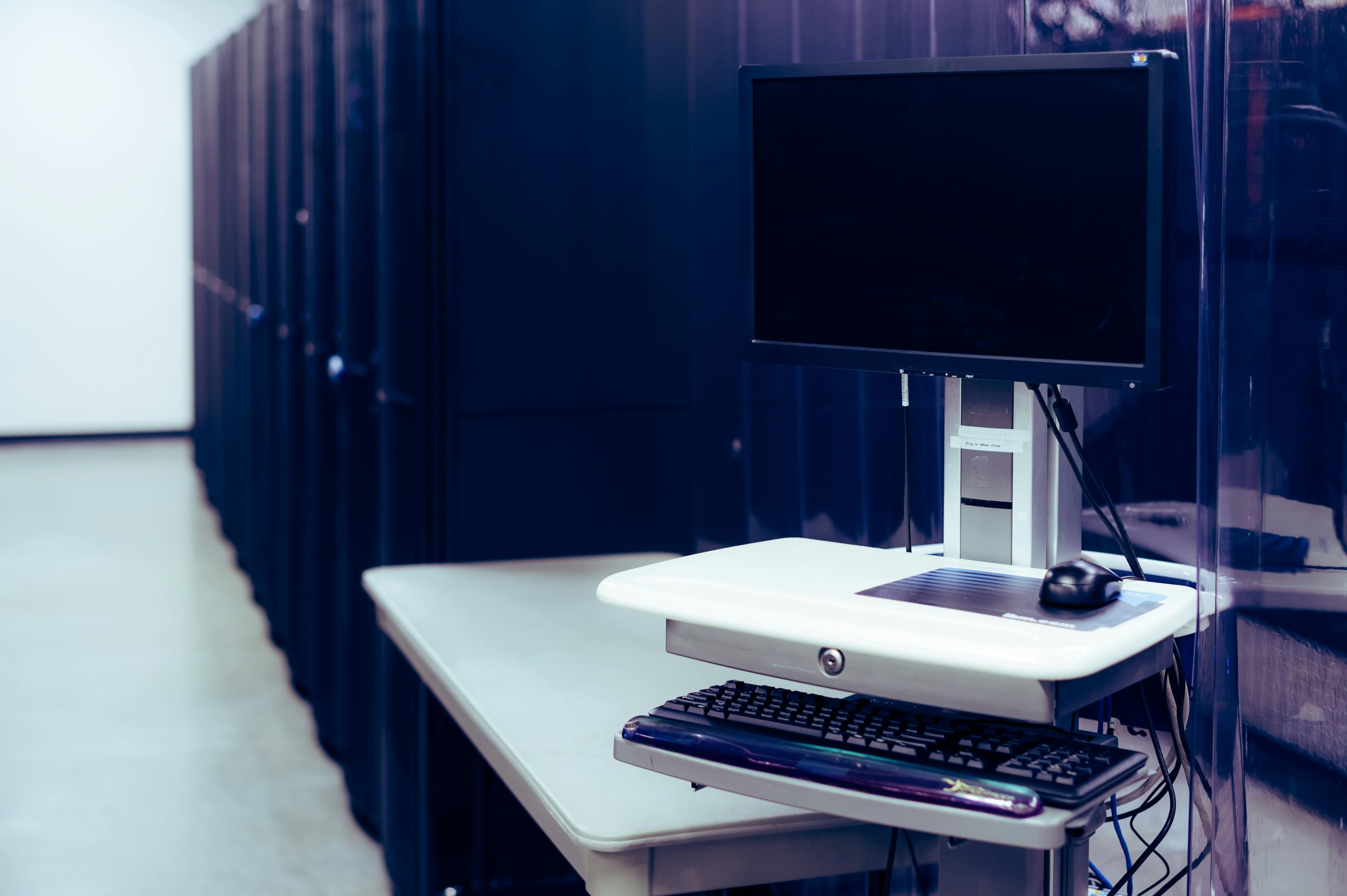 Computer workstation positioned in front of server racks
